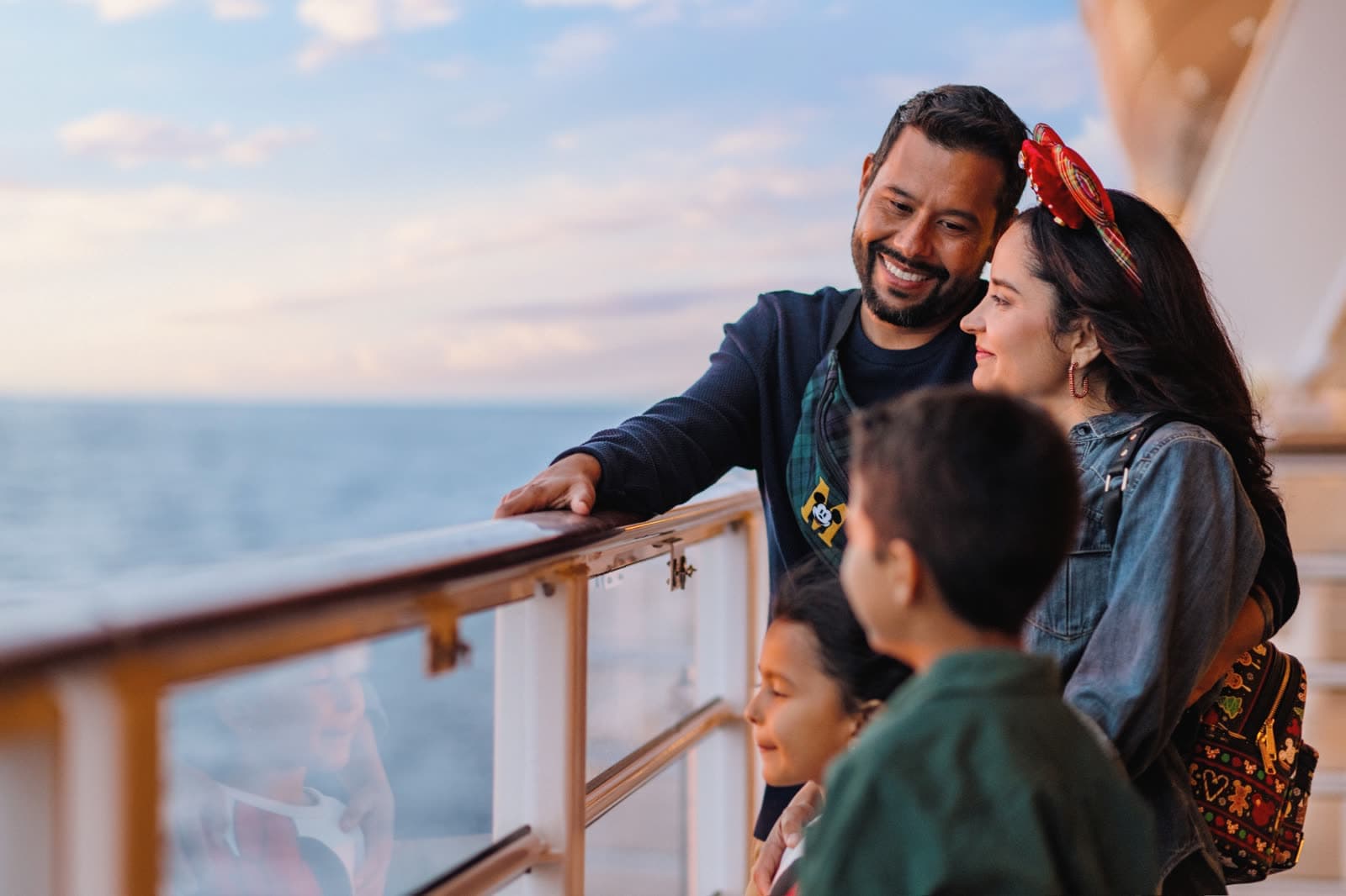 Familia en la cubierta de un barco de Disney Cruise Line al atardecer